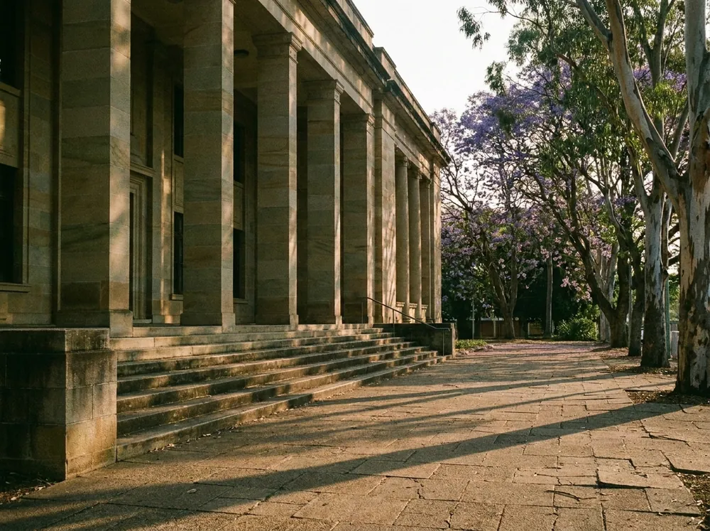The sandstone colonnade and front steps of a Queensland courthouse at golden hour