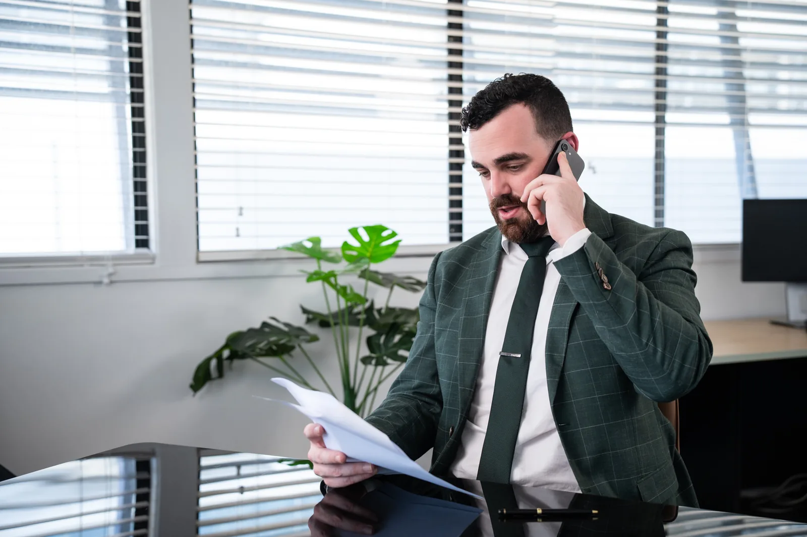Damon Laffin on the phone at his desk reviewing a document