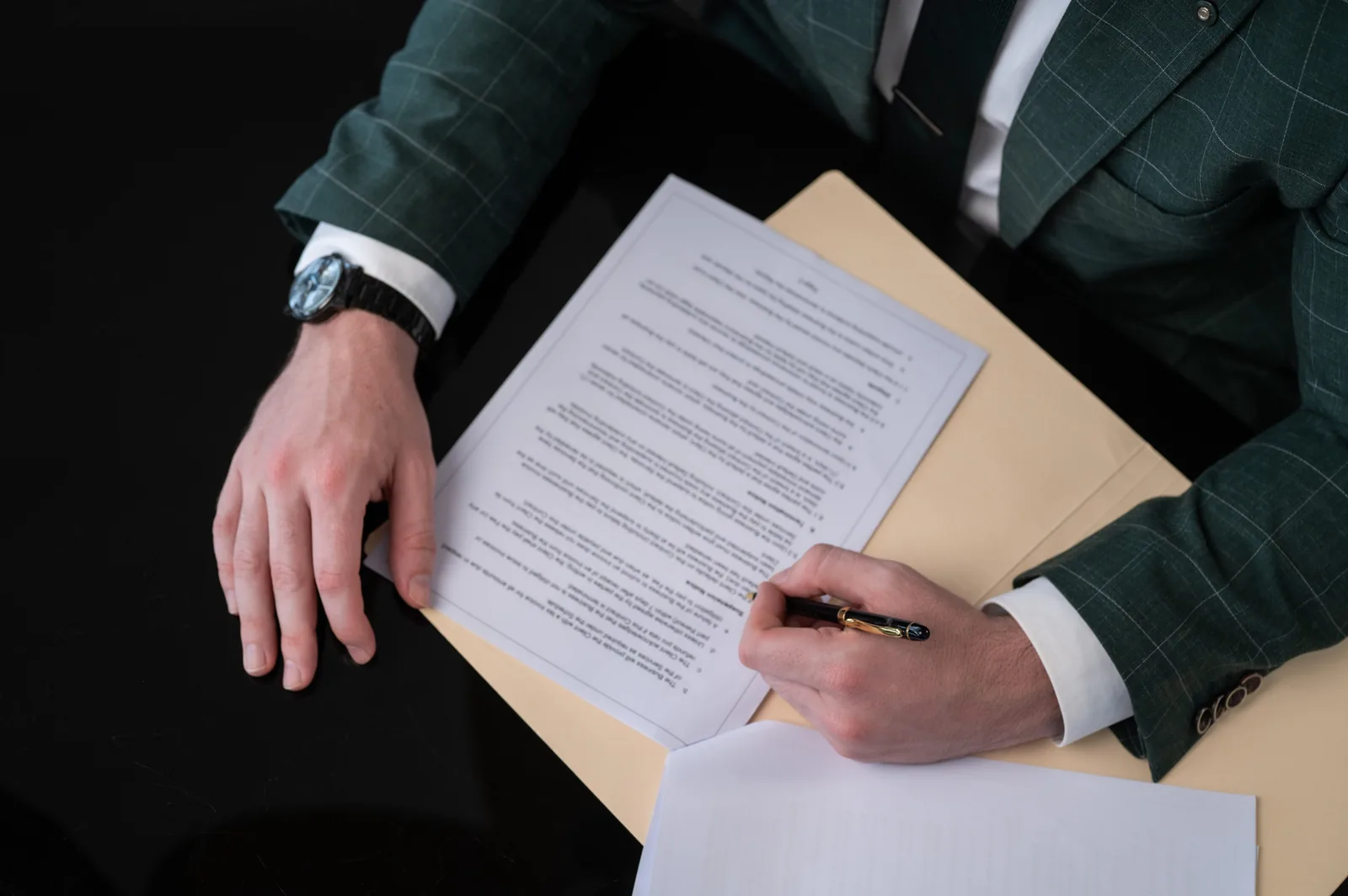 Close crop of hands signing a legal document