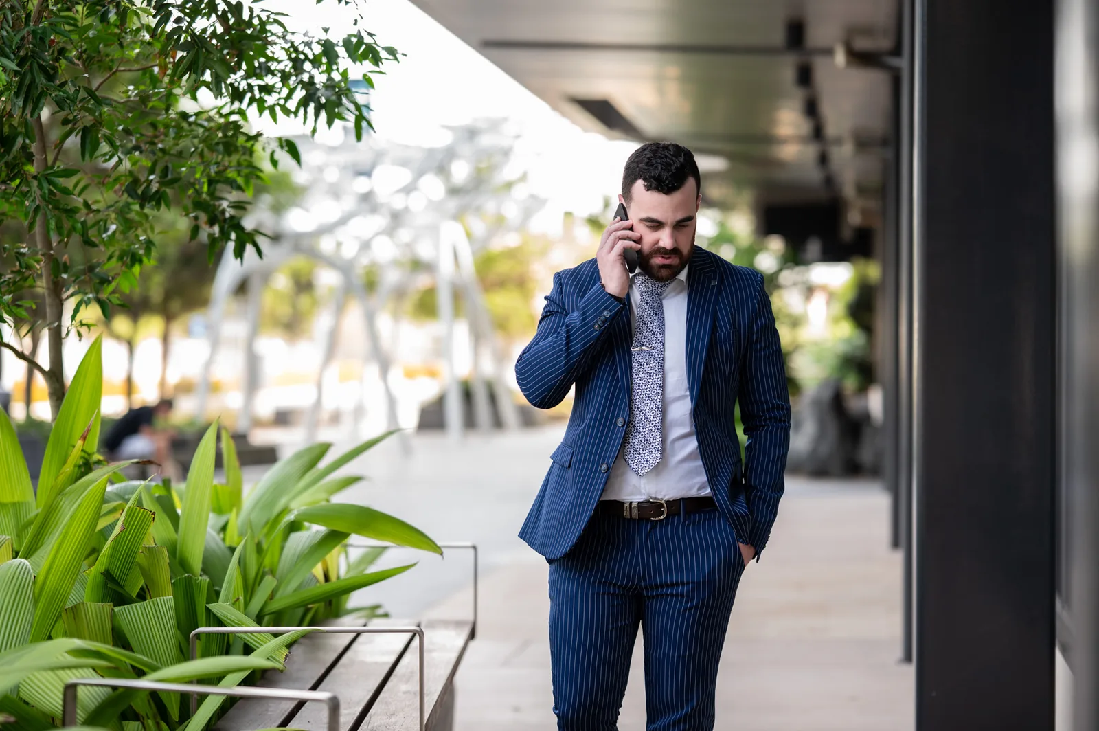 Damon Laffin on the phone walking past planting outside the office