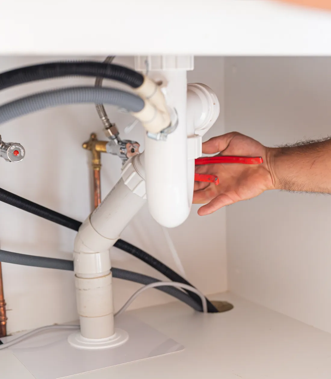New waste and supply pipework under a kitchen sink