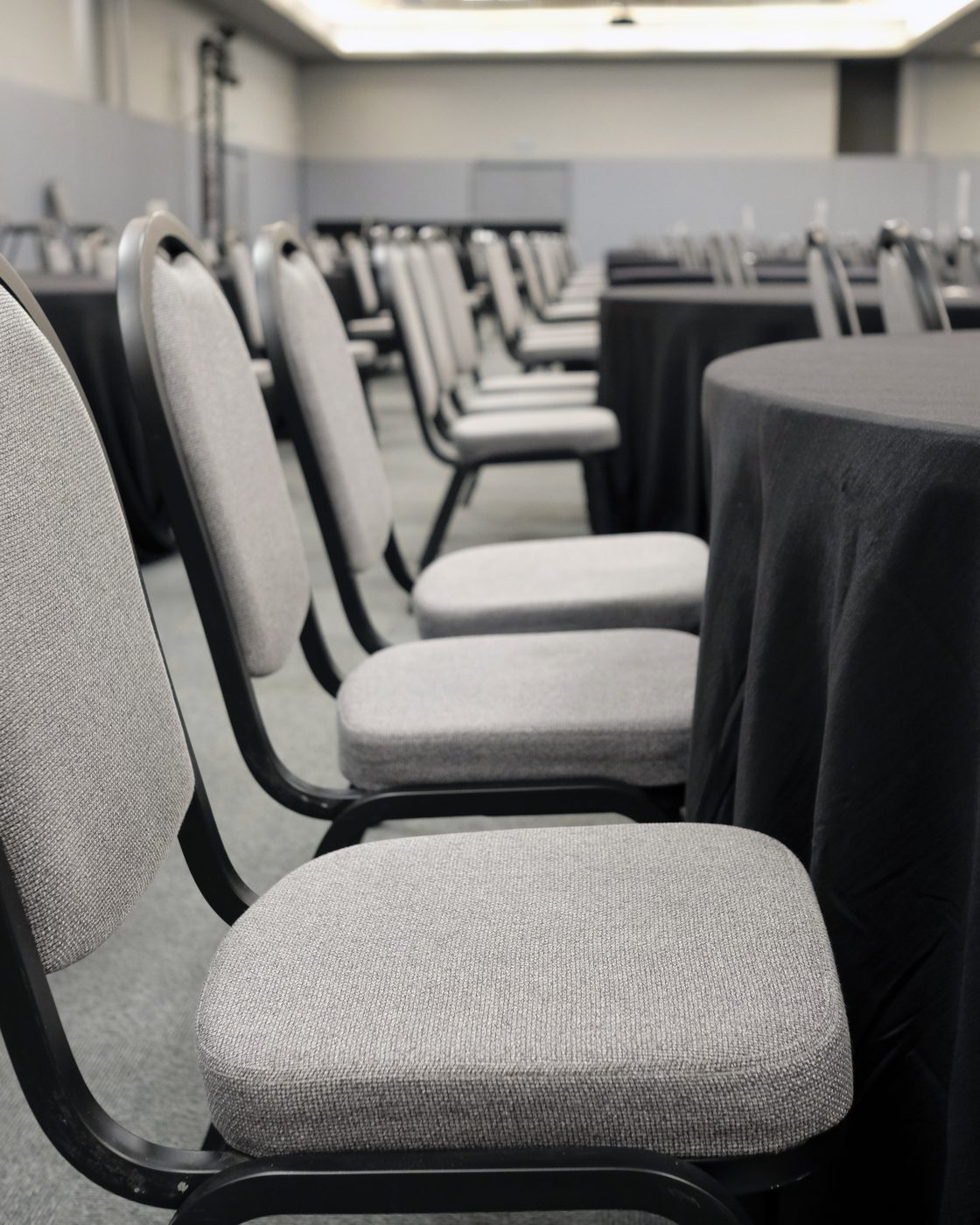 Rows of grey banquet chairs set out in an empty function room