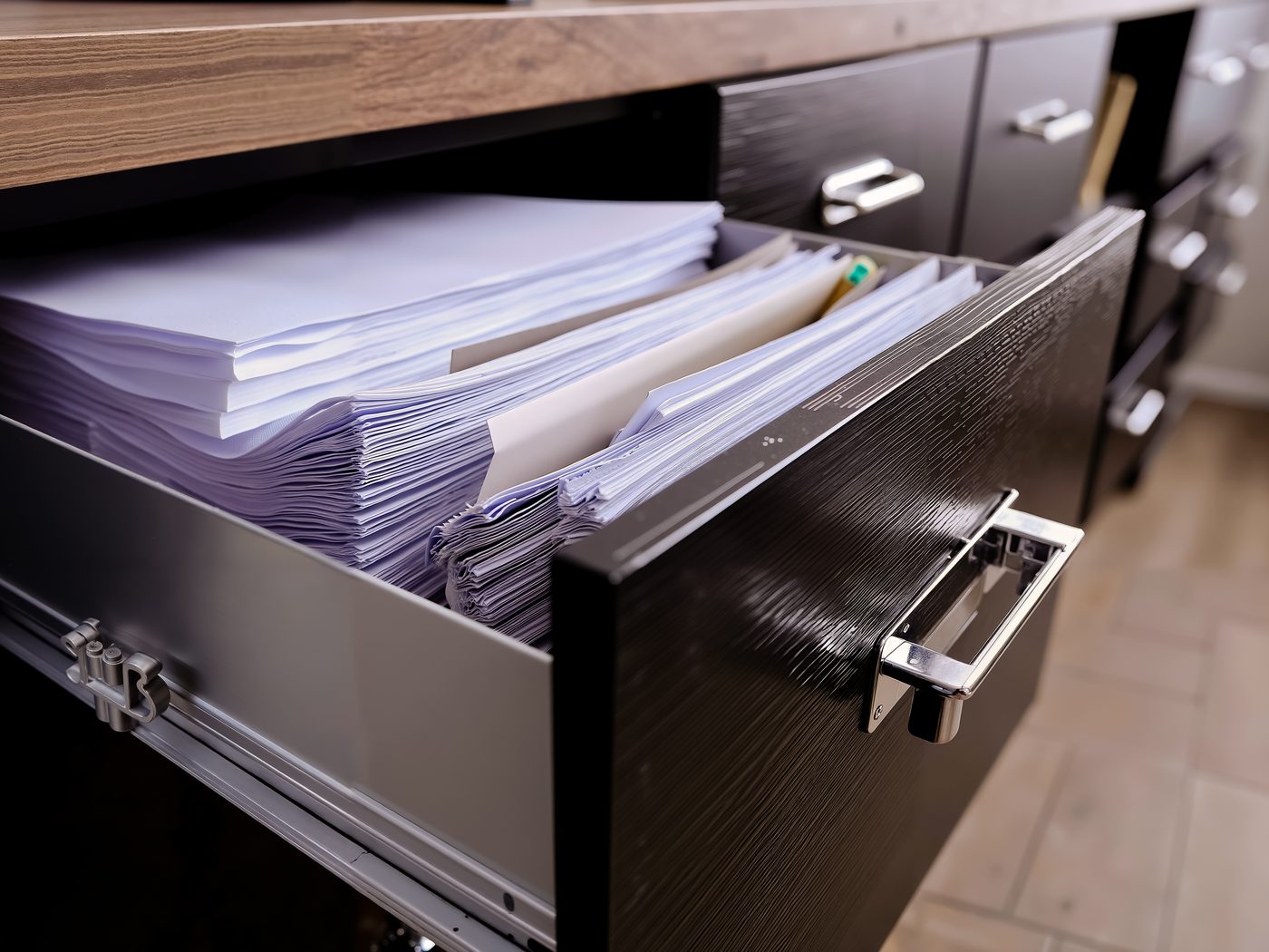 Open filing cabinet drawer packed with document folders