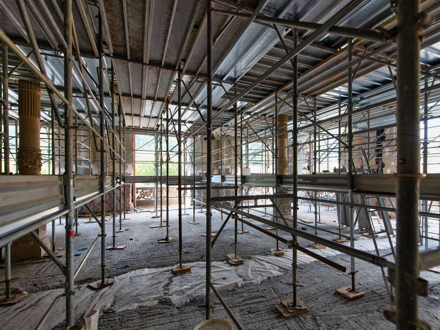 Scaffolding standing in an unfinished interior with the work stopped