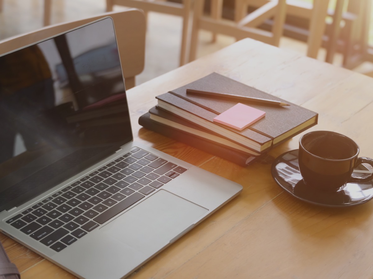 Laptop open on an otherwise tidy office desk in warm morning light