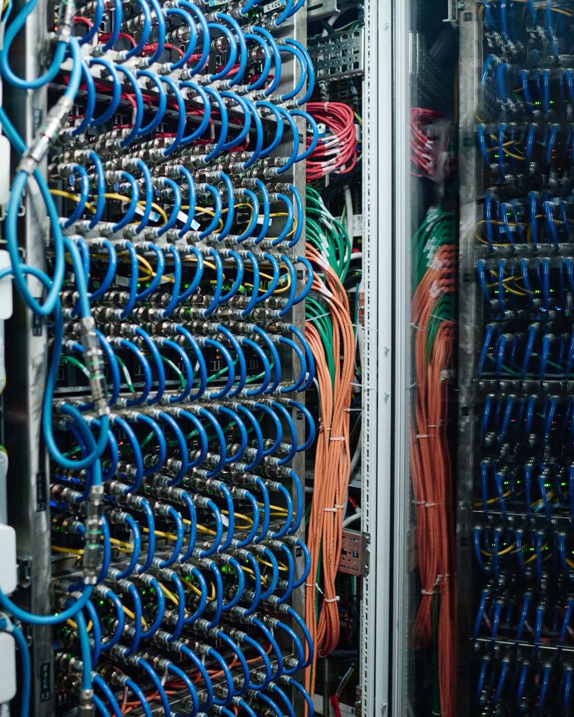 Server rack with patch cables running to a network switch in a small equipment room