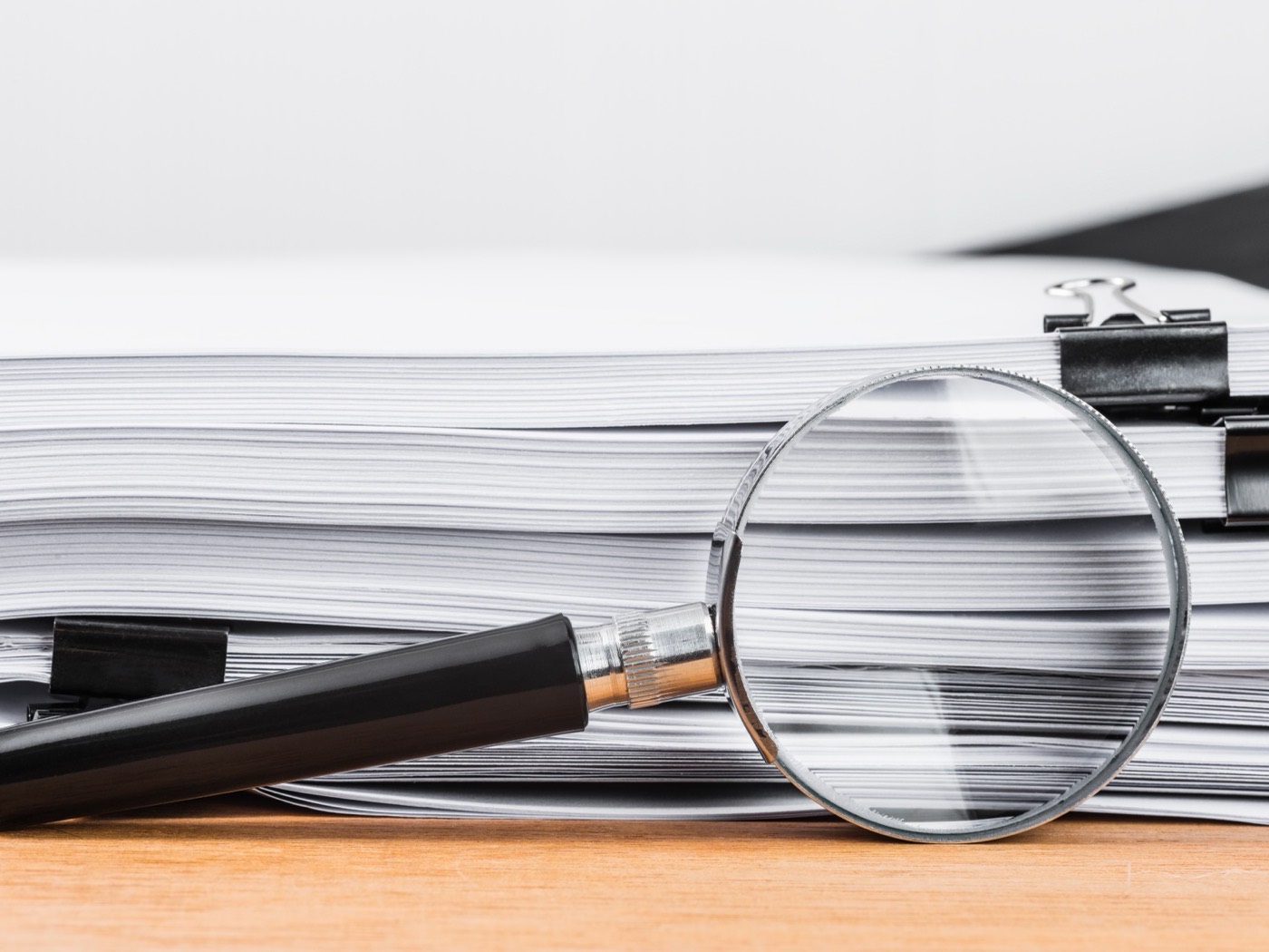 Close up of a printed policy schedule with a magnifier resting on the fine print
