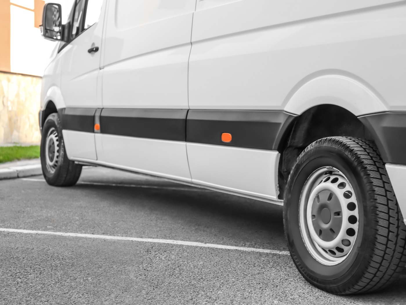 Work van parked on hardstanding beside a yard fence