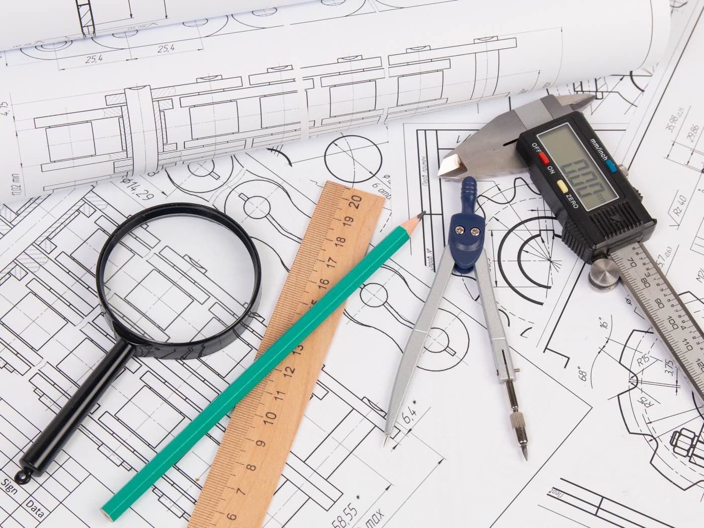 Technical product drawing and a prototype part on a workbench