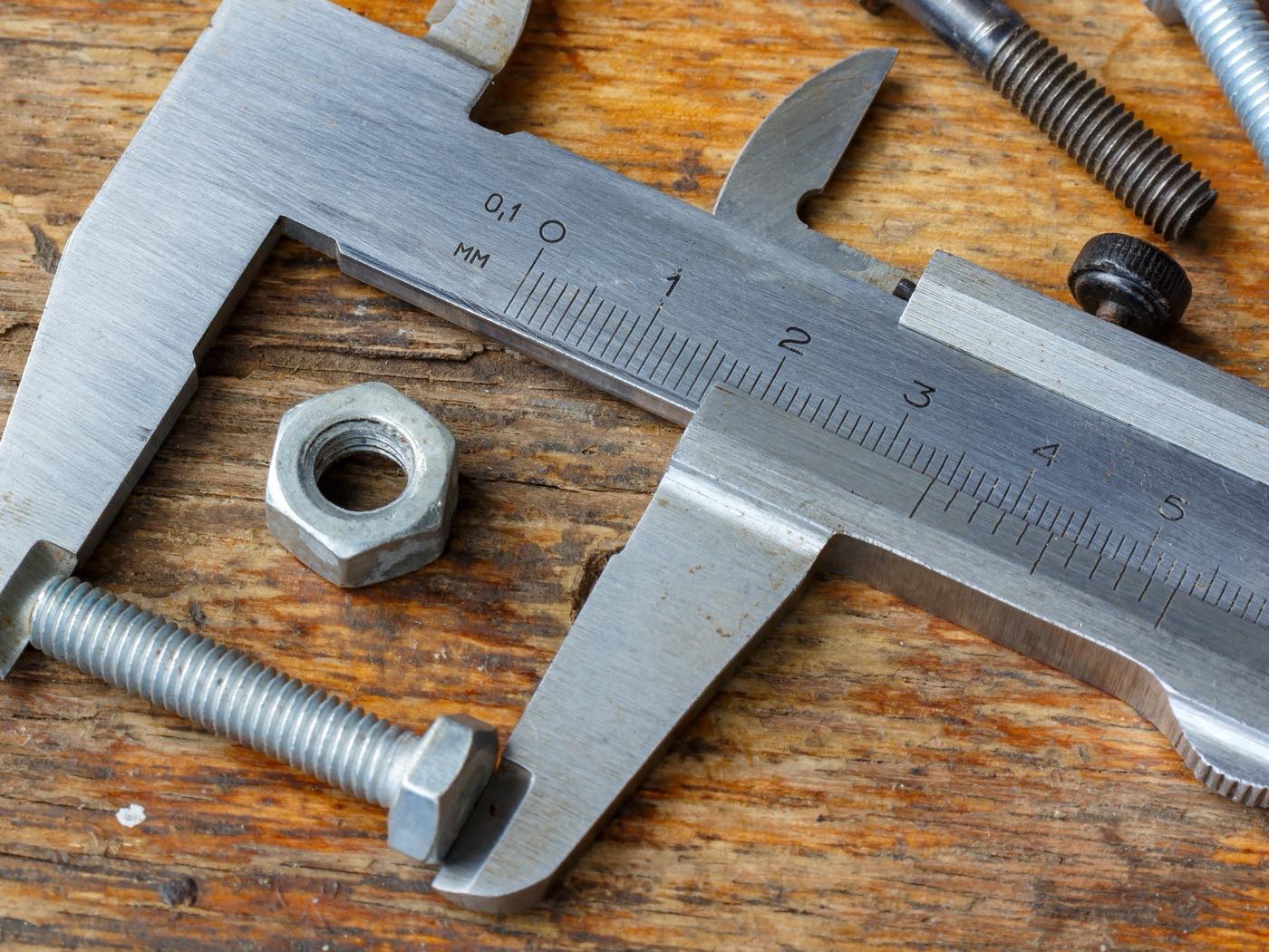 Quality control bench with calipers and gauges beside a machined part