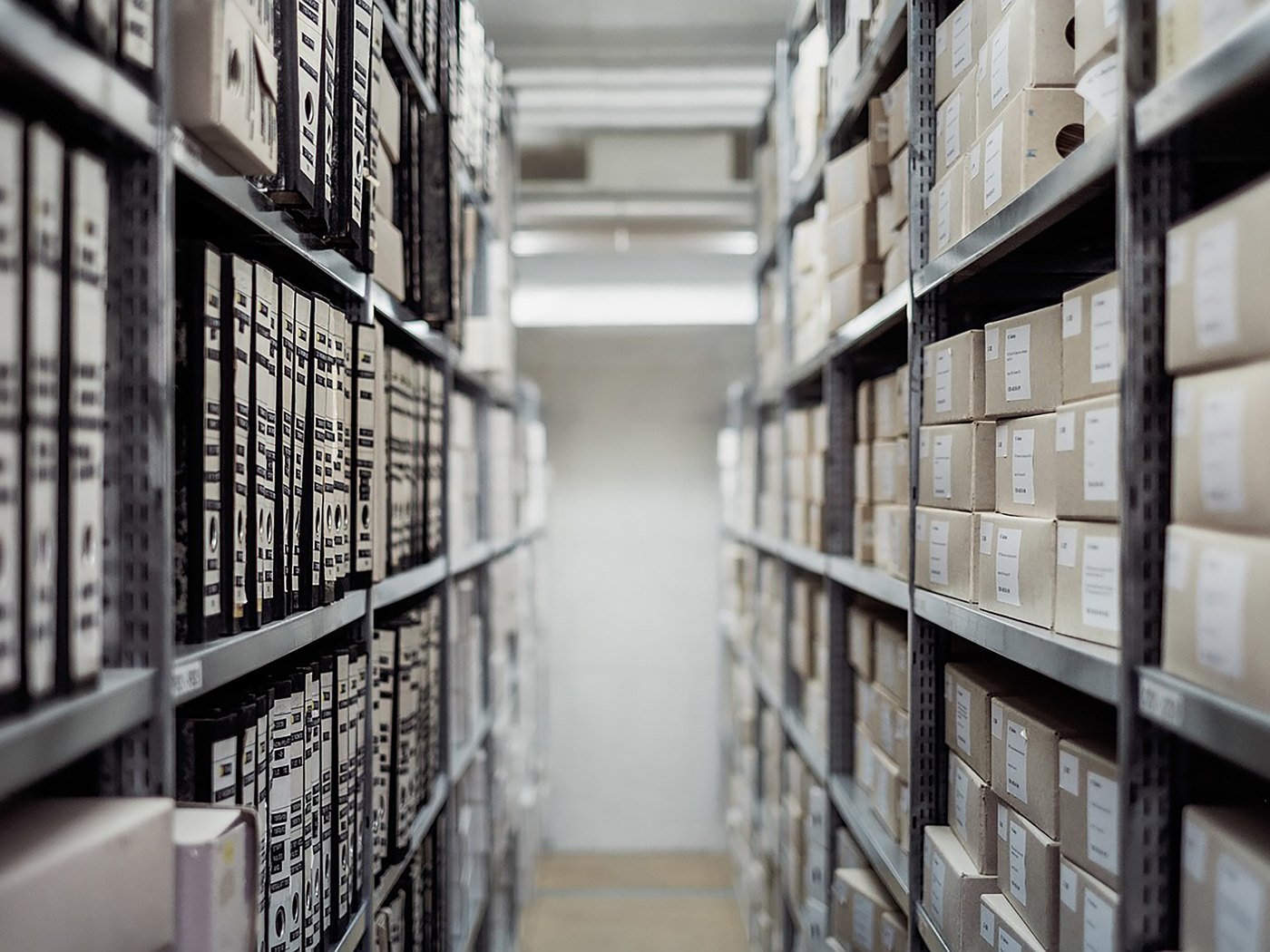 Archive boxes of closed project files stacked on shelving