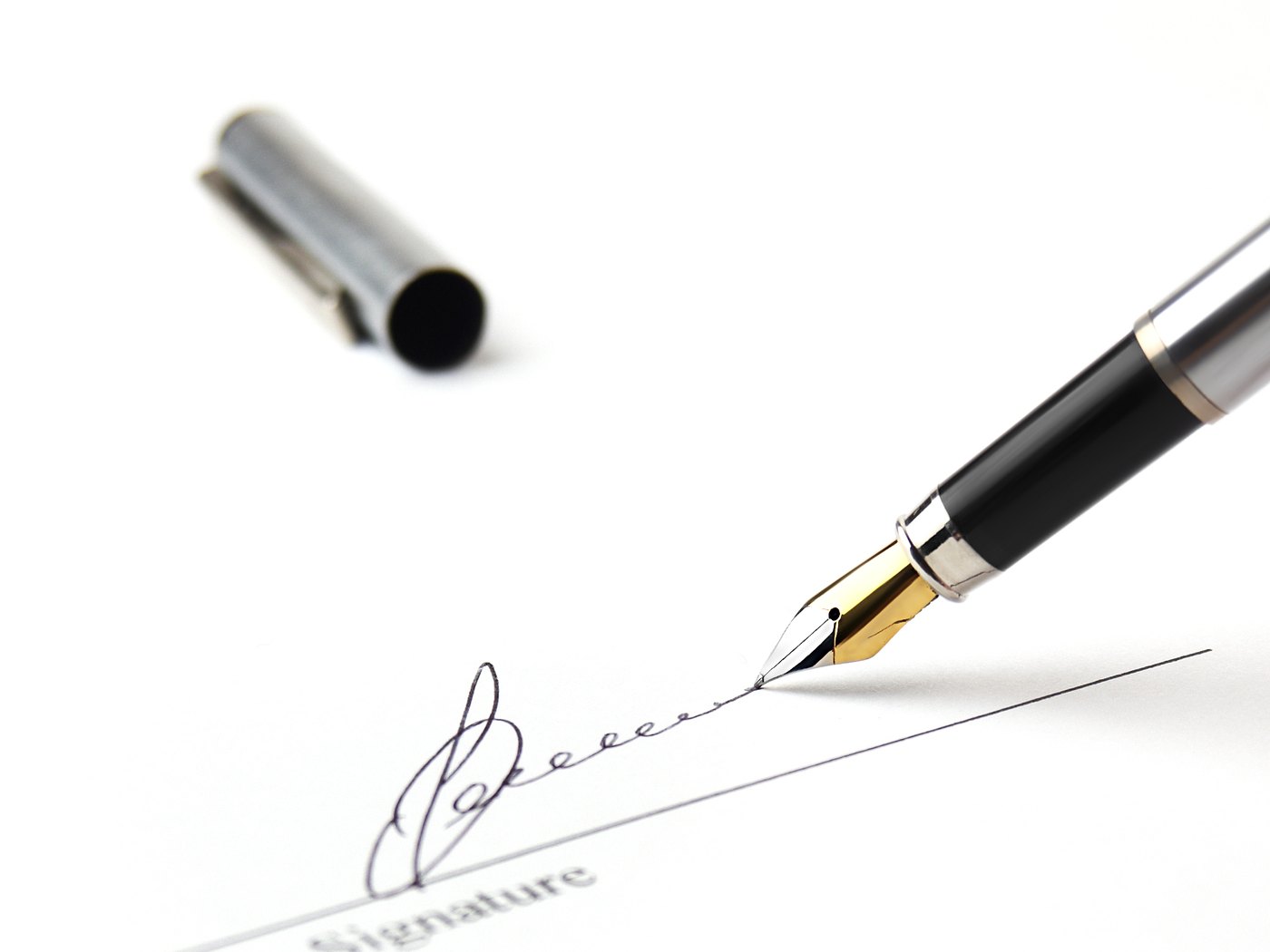 Fountain pen signing the signature line of an agreement