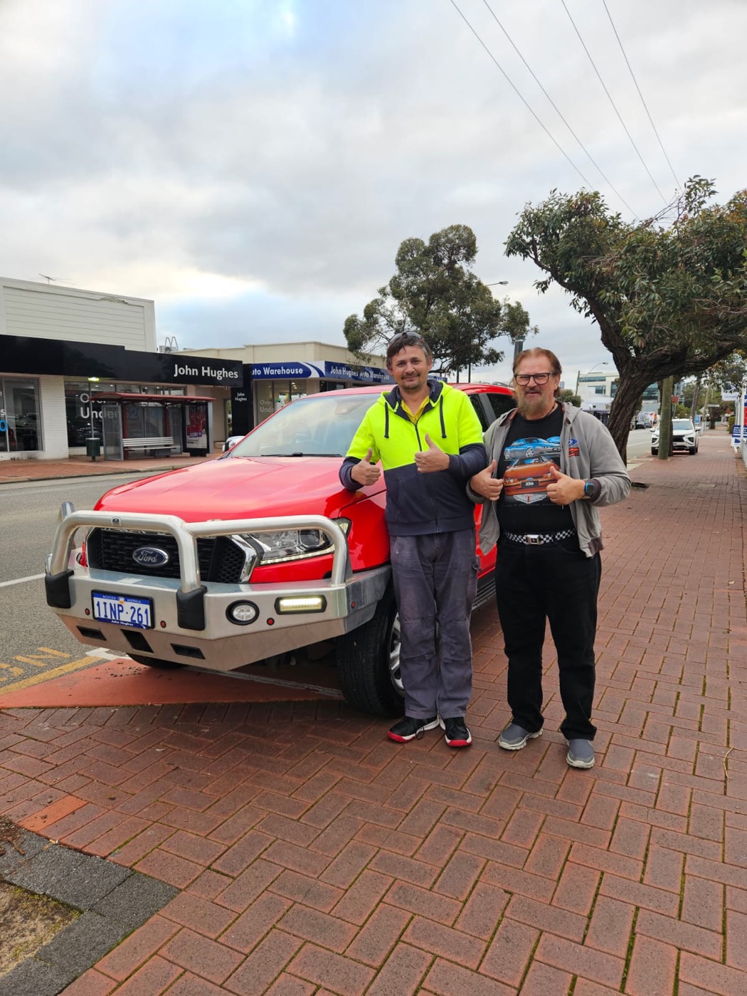 Two customers beside a red Ford Ranger