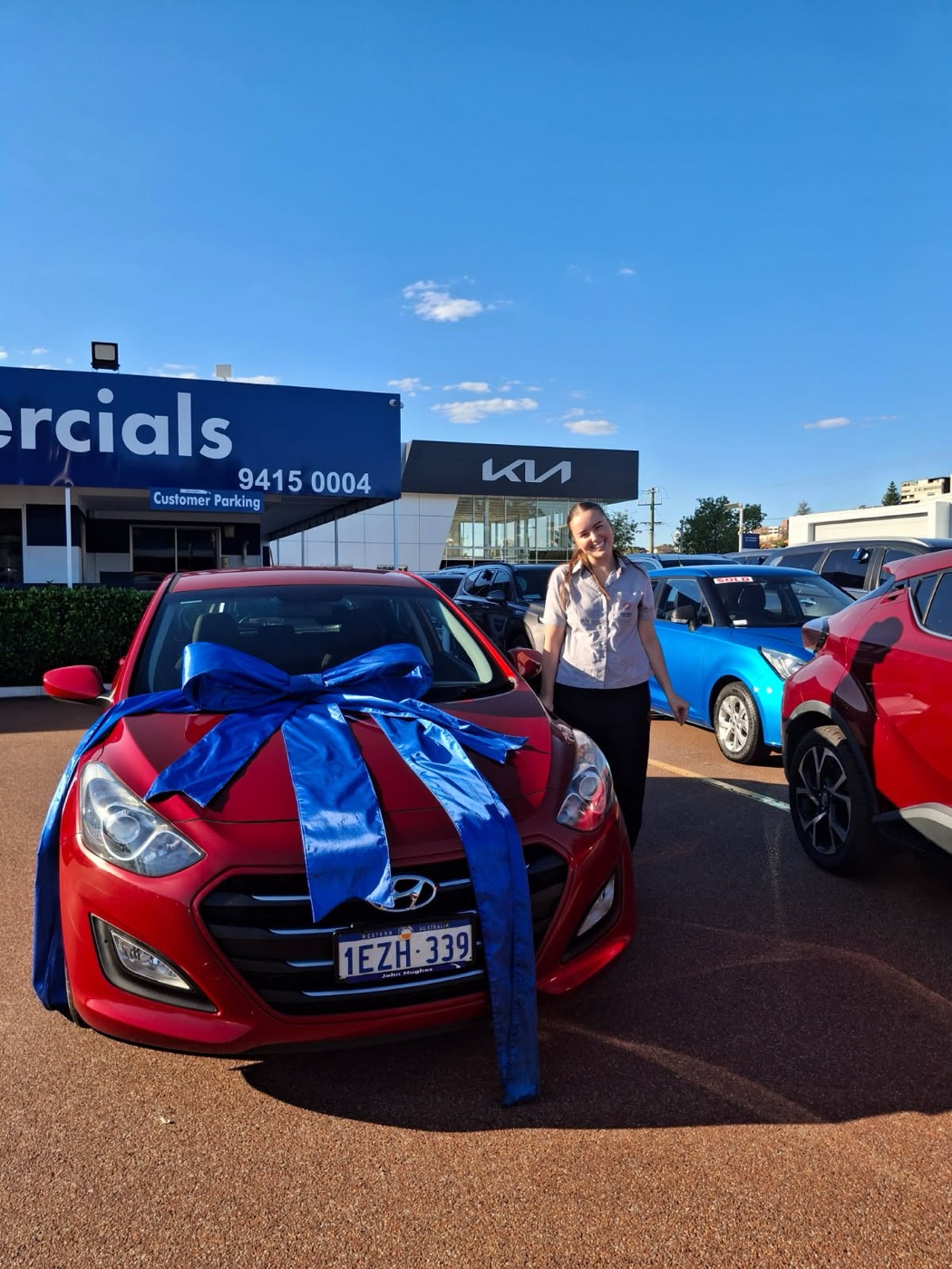 A customer with a red Hyundai, ribbon still on the bonnet